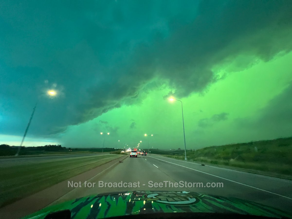 Un cielo verde sobre una carretera mientras se aproxima una fuerte tormenta.